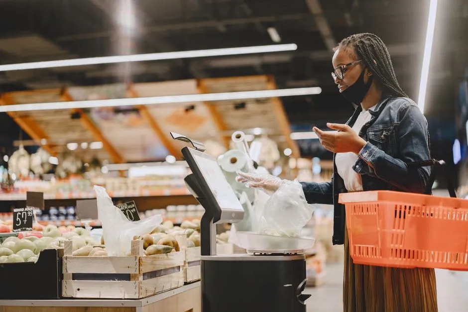 Shopper weighing fresh groceries on a supermarket scale
